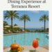 Poolside dining at Terranea Resort with a burger, fries, grilled salmon, and a tropical cocktail overlooking the ocean.