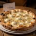 Freshly baked white pizza with mozzarella and black pepper at Pizzana restaurant in Los Angeles.