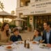 Family of four dining outdoors at The Terrace restaurant at The Maybourne Beverly Hills, enjoying pasta dishes at sunset.