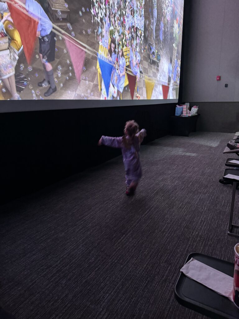 Charlotte dancing in front of the screen during her private birthday screening at the Bay Theater