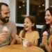 Family of four enjoying a sweet dessert outing together at a restaurant.