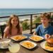 Family of four enjoying oceanfront dining in Malibu with burgers, fries, and clam chowder at a family-friendly restaurant.