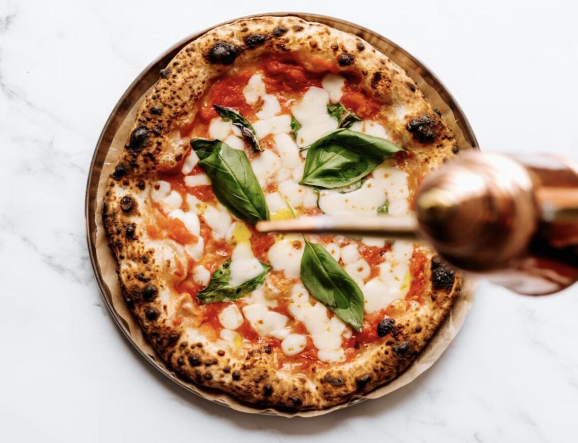 A classic Neo-Neapolitan margherita pizza with charred crust, fresh mozzarella, and basil.