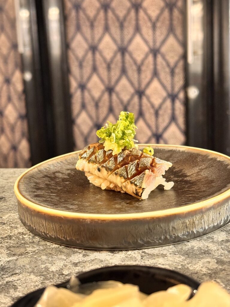 Scored silver-skin fish nigiri topped with scallion and ginger at TAIKUN