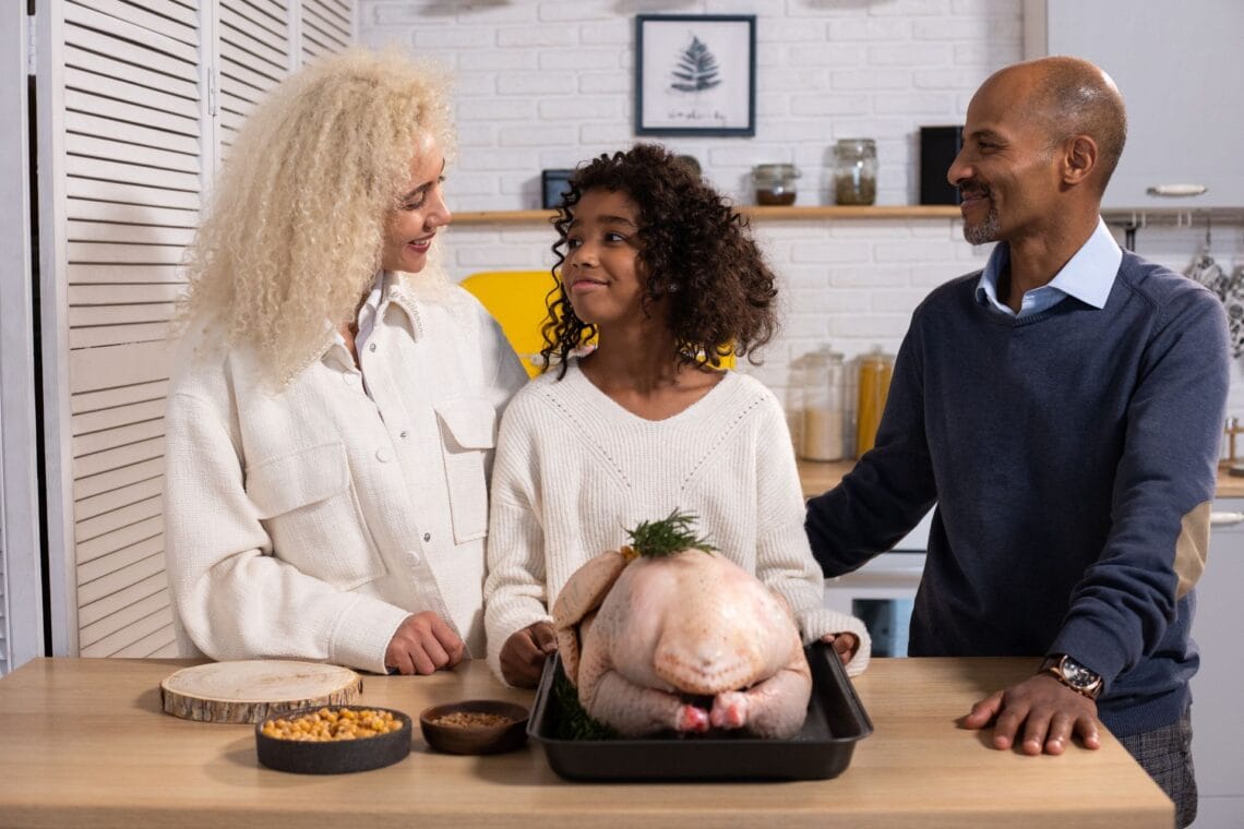 A family preparing a Thanksgiving turkey together in the kitchen