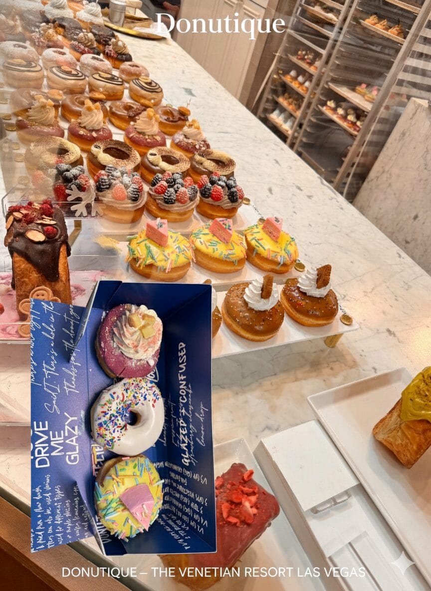 A vibrant display of luxury donuts and cruffins at Donutique in The Venetian Las Vegas, featuring gold-leaf accents, fresh berries, and artisan glazes on a marble counter.