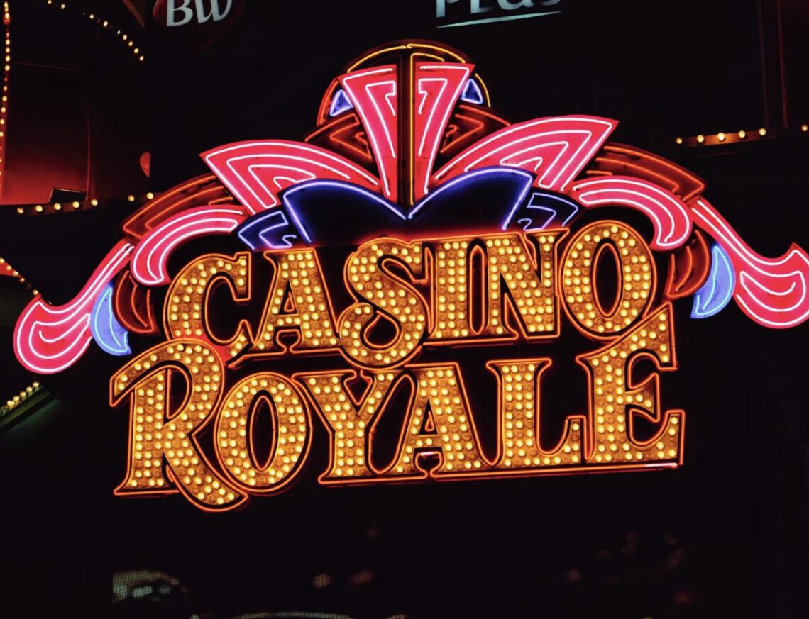 A vibrant illuminated "Casino Royale" neon sign glowing at night on the Las Vegas Strip.