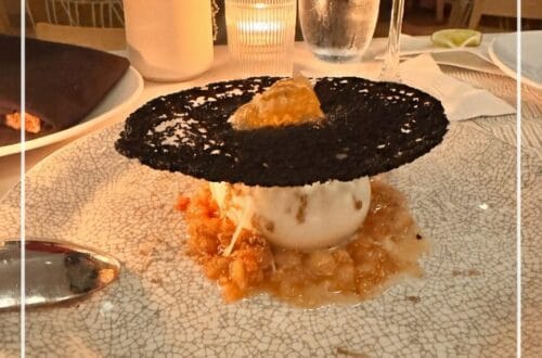 A high-end dessert and cocktail on a white textured plate at a Los Angeles restaurant, featuring a Pinterest-style text overlay for an inKind app guide.