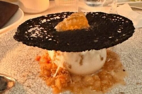 A high-end dessert and cocktail on a white textured plate at a Los Angeles restaurant, featuring a Pinterest-style text overlay for an inKind app guide.