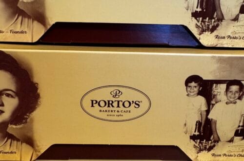 Close-up of yellow Porto’s Bakery & Cafe boxes featuring a vintage black and white portrait of founder Rosa Porto and her children.
