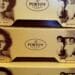 Close-up of yellow Porto’s Bakery & Cafe boxes featuring a vintage black and white portrait of founder Rosa Porto and her children.