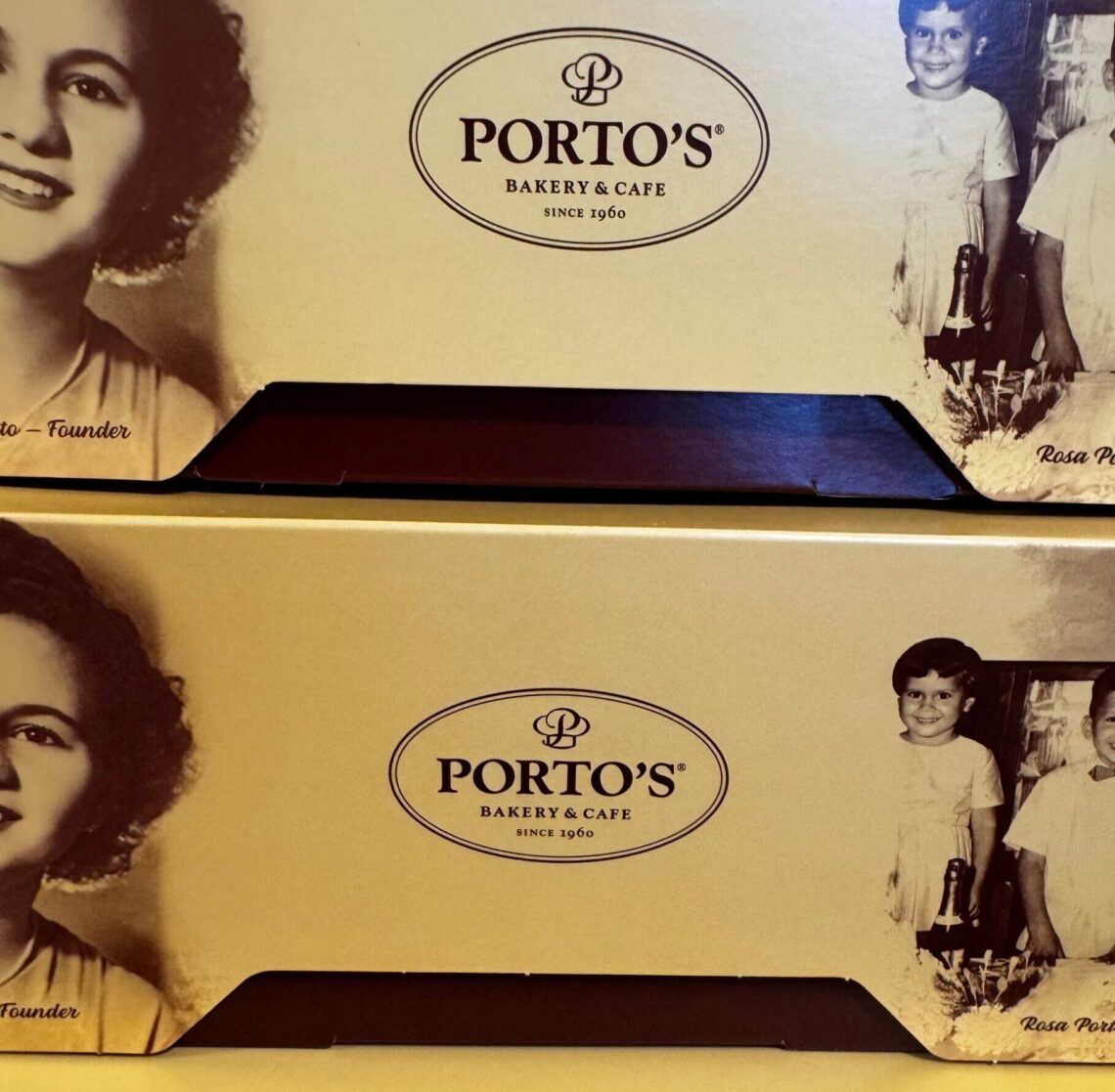 Close-up of yellow Porto’s Bakery & Cafe boxes featuring a vintage black and white portrait of founder Rosa Porto and her children.