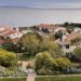 High-angle view of Terranea coastal resort with white buildings and red-tile roofs overlooking the ocean under a cloudy sky.