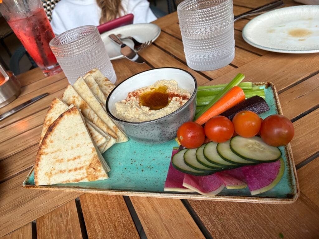 Roasted garlic hummus served with grilled pita and seasonal vegetables