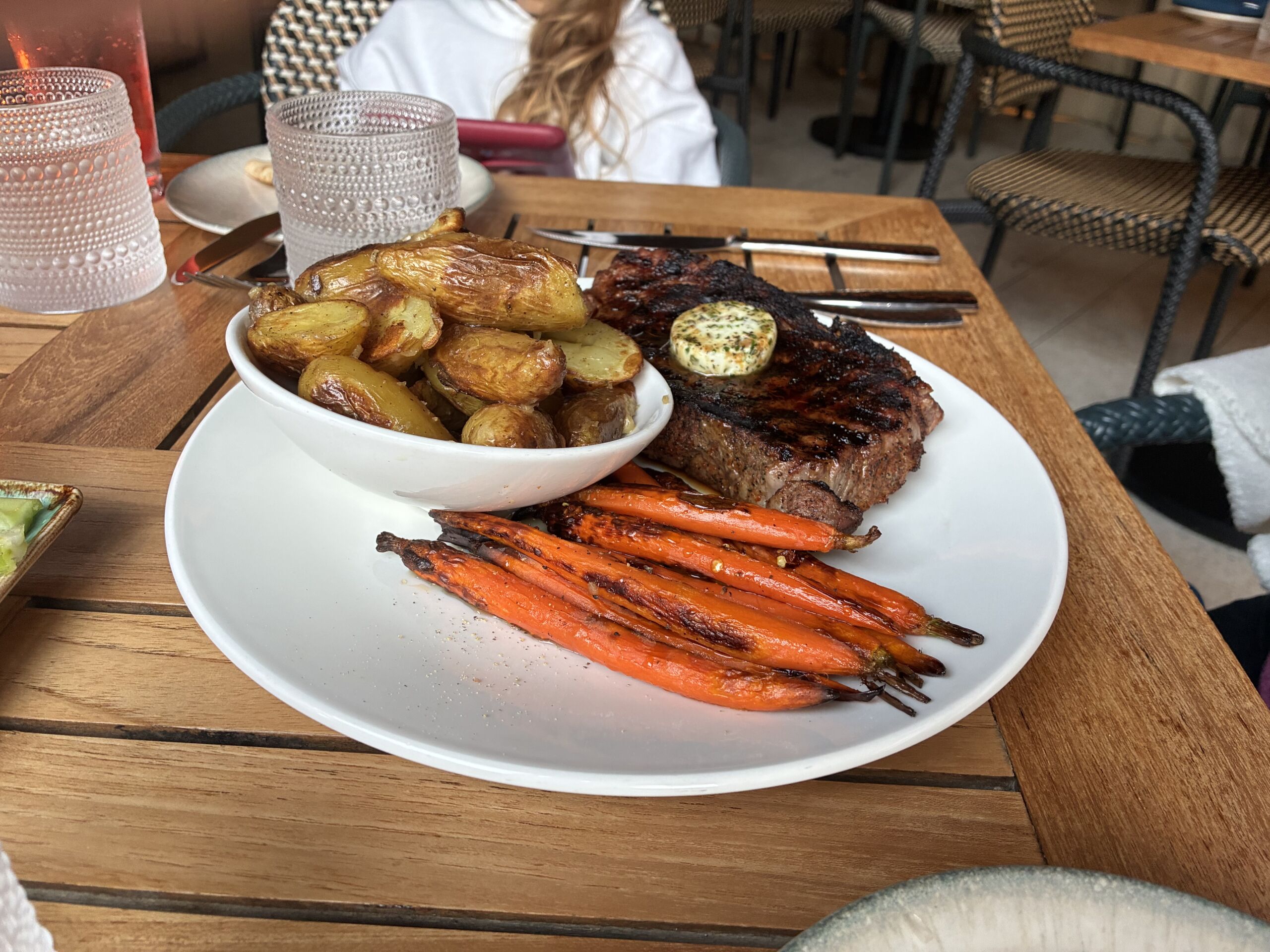Coffee spice rubbed 14 oz prime ribeye with honey-glazed heirloom carrots, roasted fingerling potatoes, and garlic herb butter at Shoreside Restaurant and Bar in Santa Monica