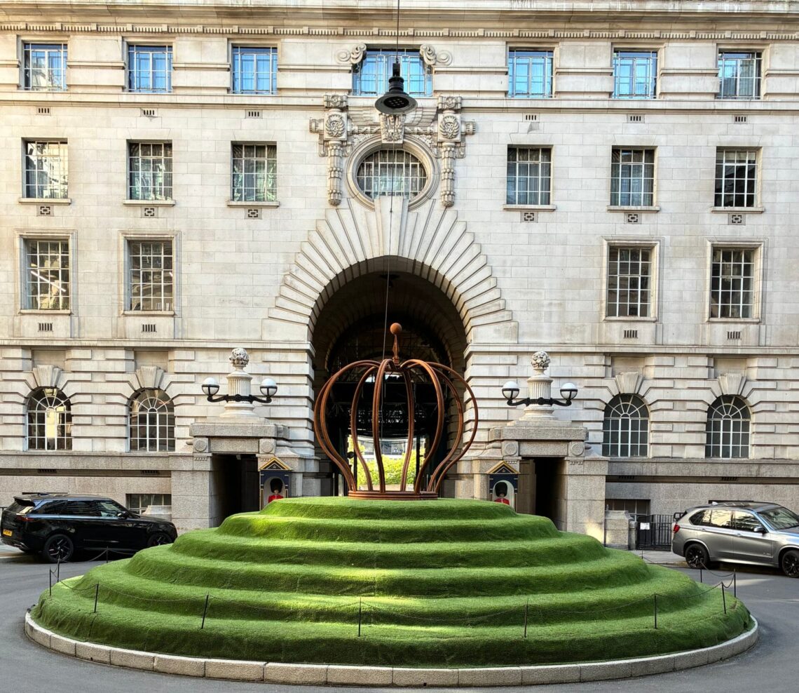 The entrance courtyard of the London Marriott Hotel County Hall, featuring a tiered circular green lawn and sculptural centerpiece in front of the hotel’s ornate stone façade.