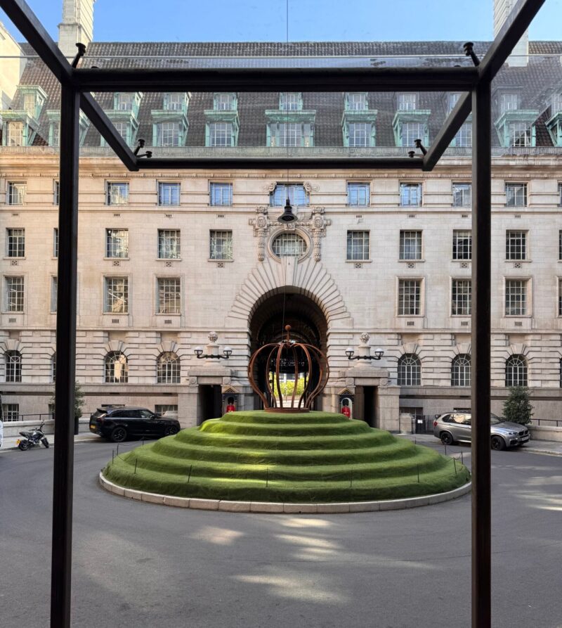 Entrance courtyard of the London Marriott Hotel County Hall in London, featuring a circular tiered green lawn, sculptural seating, and the hotel’s historic stone façade.