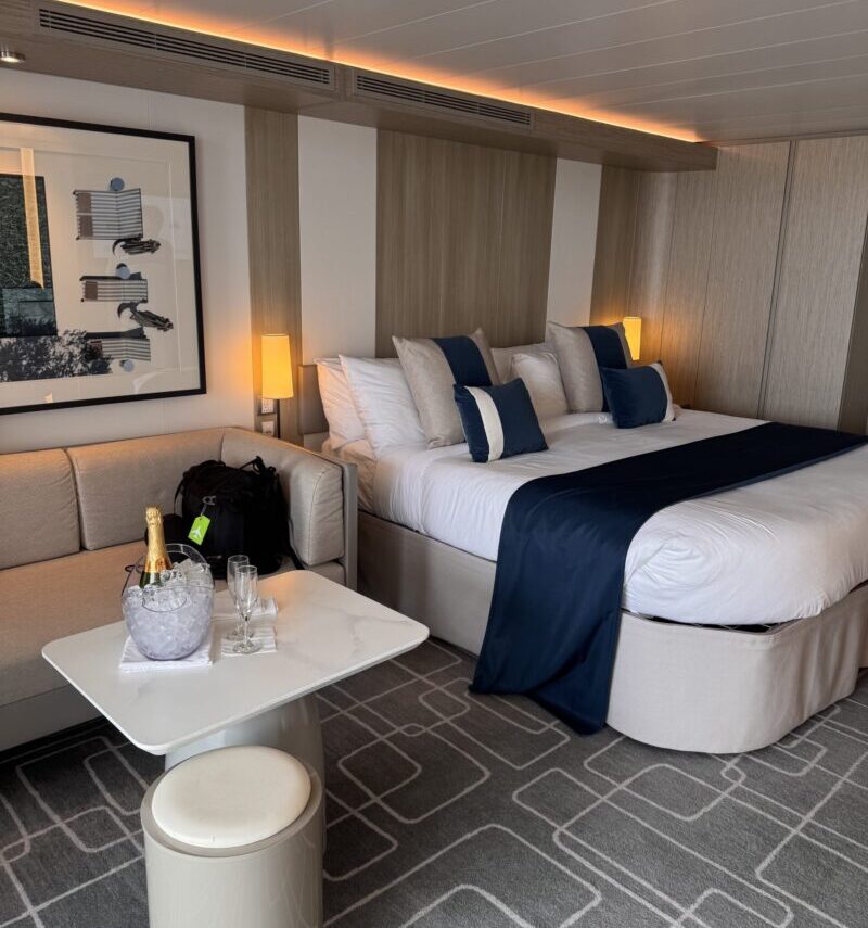Magic Carpet Sky Suite in The Retreat on Celebrity Apex with a king bed, sofa, and champagne