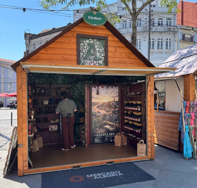 A wooden market stall selling handmade goods at Mercado Alegria in Porto