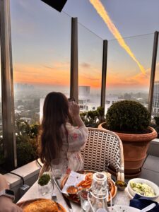 Madeline enjoying the sunset view and her meal at The Roof at The West Hollywood EDITION