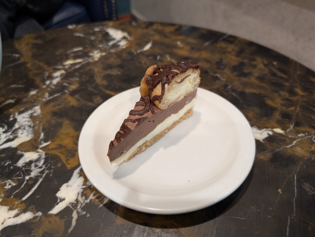 A rich slice of chocolate cheesecake drizzled with chocolate sauce