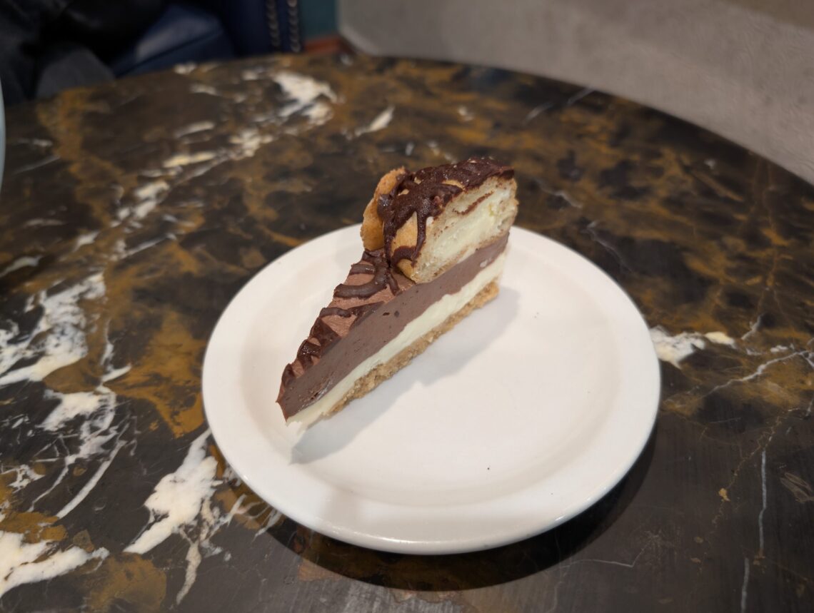 A rich slice of chocolate cheesecake drizzled with chocolate sauce