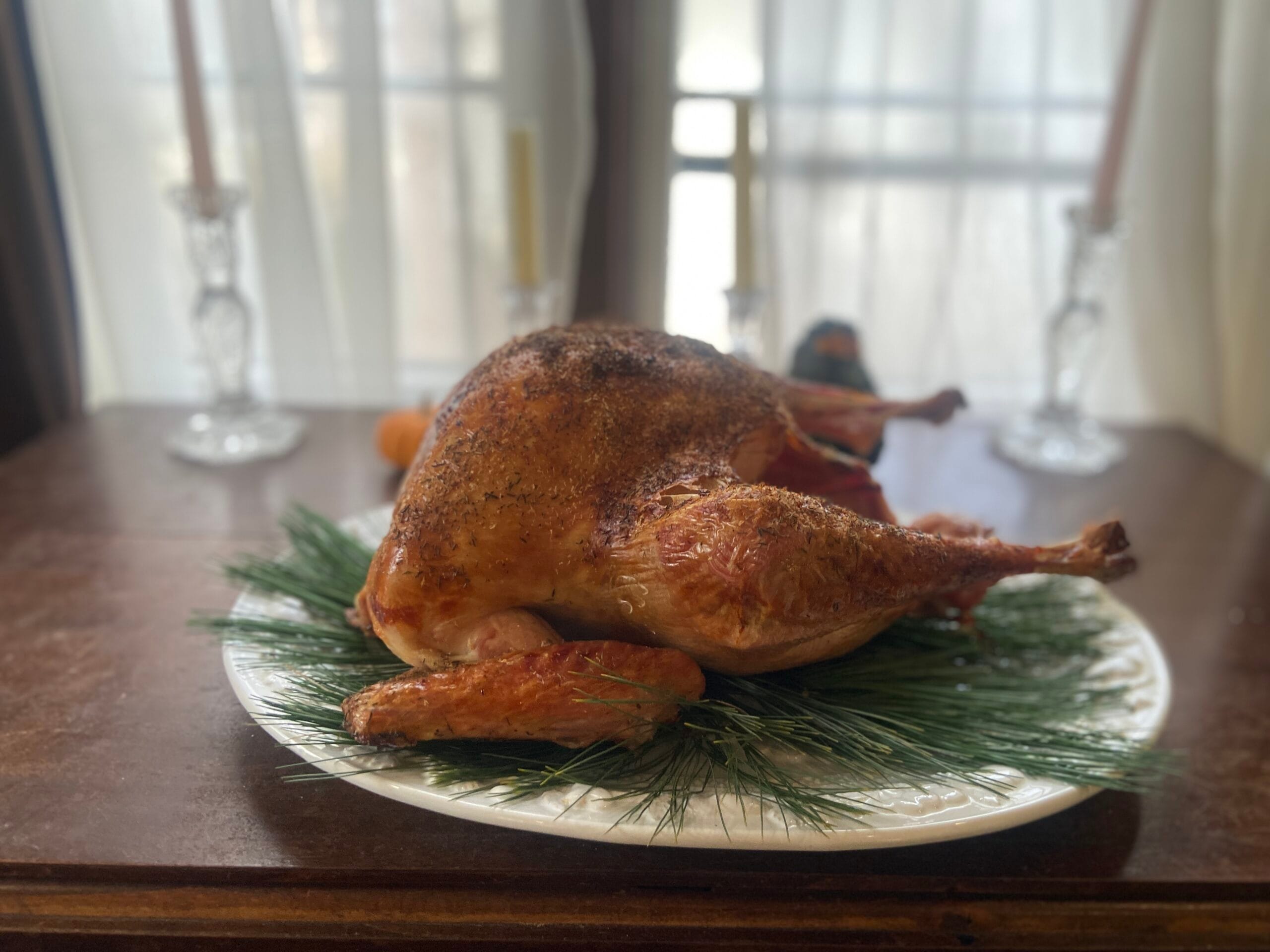 A whole roasted turkey with crispy, golden-brown skin displayed on a table