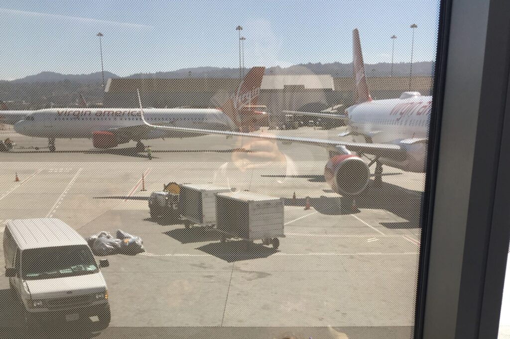 Virgin Atlantic plane at the gate, seen through the terminal window