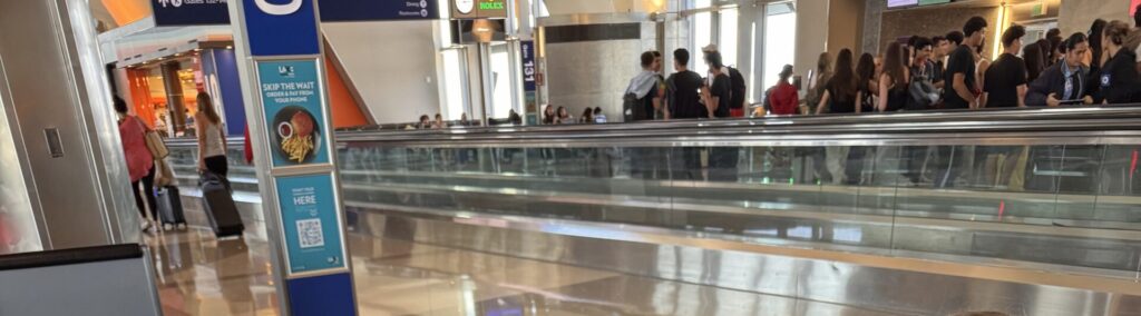 Crowded terminal walkway at LAX before a Virgin Atlantic flight to London