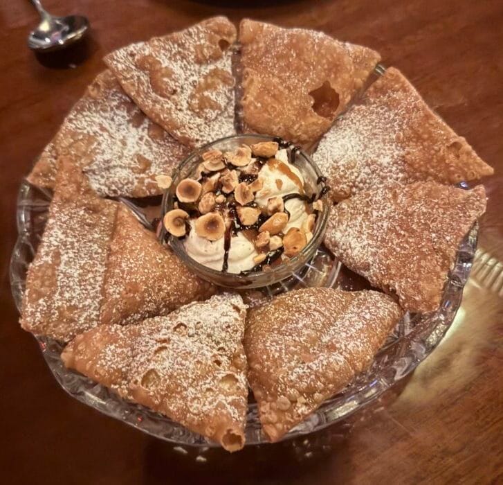 Hazelnut Cannoli Sbagliati at Bad Roman: broken cannoli shell pieces arranged around a bowl of cream topped with hazelnuts.