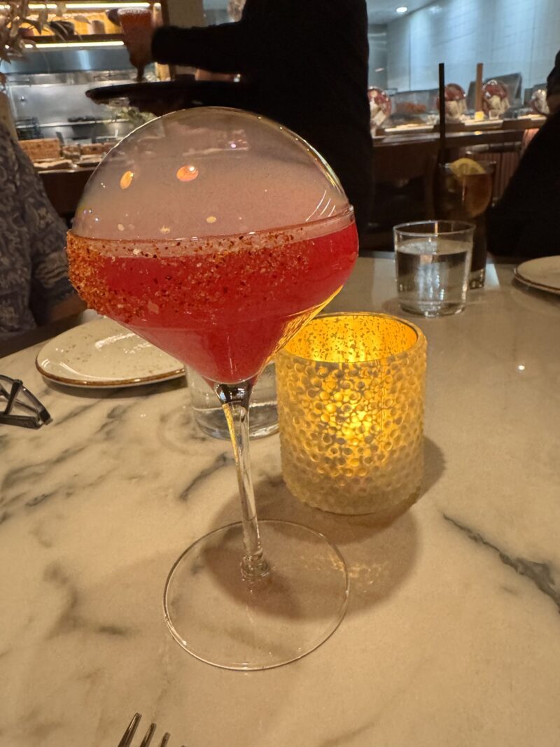 A vibrant La Flaca cocktail served at Telefèric Barcelona restaurant in Brentwood, showcasing its colorful presentation.