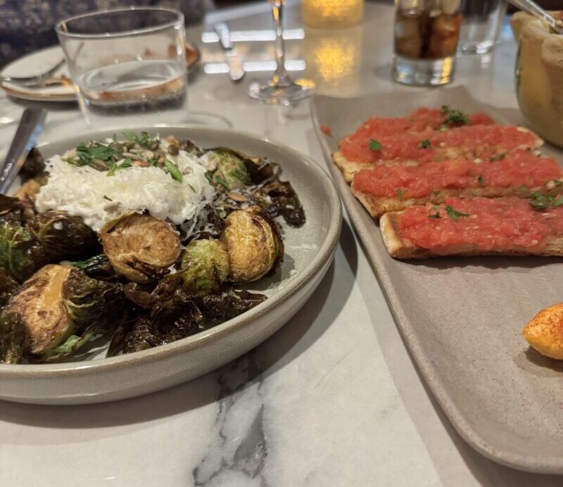 A vibrant dish featuring Brussels sprouts and Pan Con Tomate topped with chorizo butter, served at Telefèric Barcelona in Brentwood.