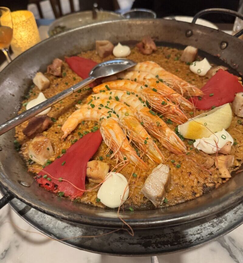 A colorful serving of Paella Mixta featuring a mix of seafood, chicken, and vegetables, captured at Telefèric Barcelona restaurant in Brentwood.