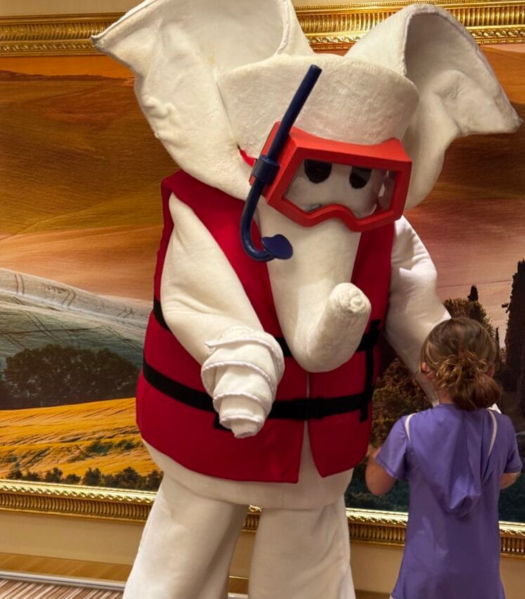 A child meeting Fatso the Elephant, Carnival’s mascot dressed in a life vest and snorkel mask, aboard the Carnival Firenze