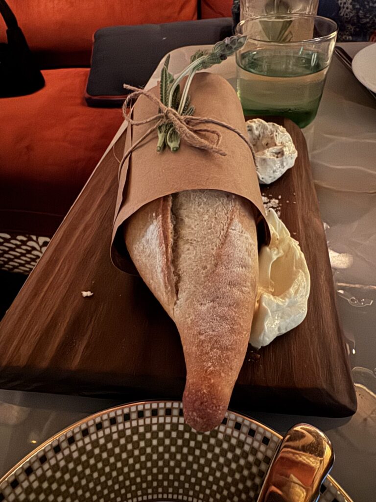 Warm baguette wrapped in brown paper and twine with truffle butter