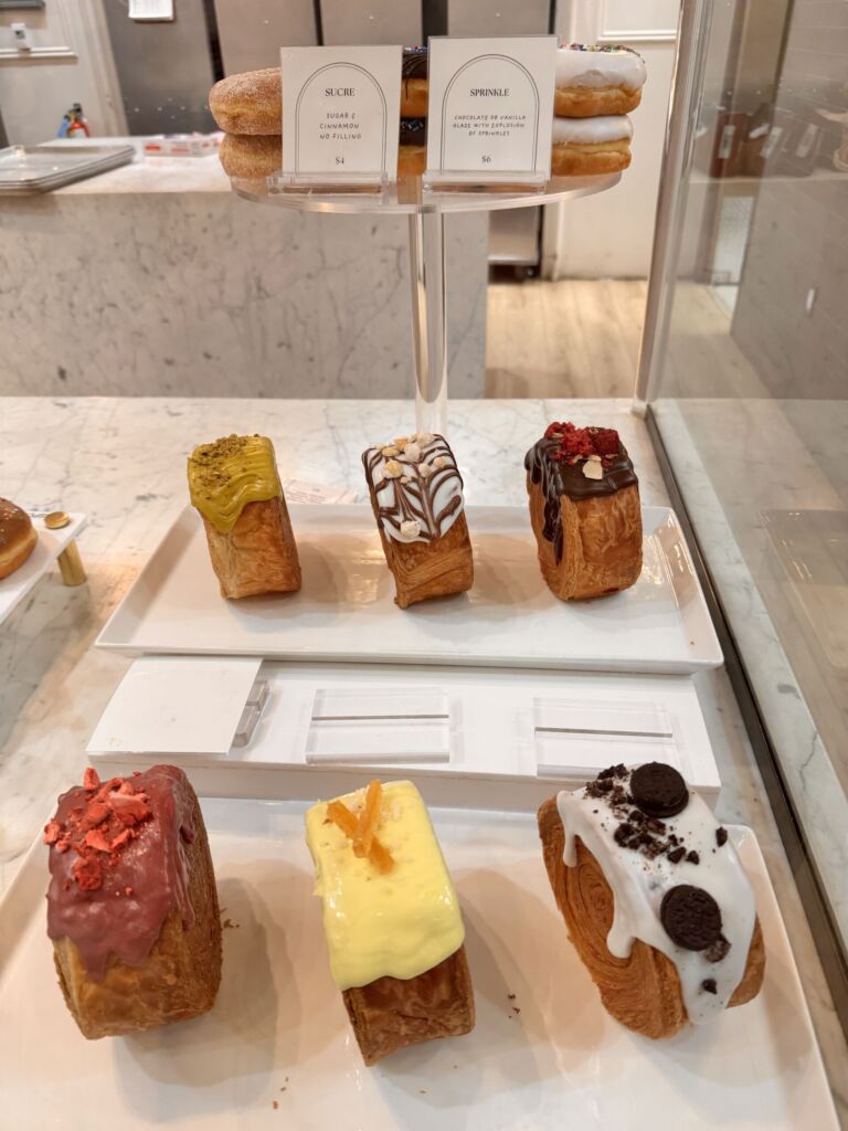 A display case of cronuts and donuts at Donutique in The Venetian, including Sucre and Sprinkle flavors