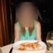 A plated lobster tail with risotto and a roasted red pepper at a cruise ship specialty restaurant, served with a glass of white wine.