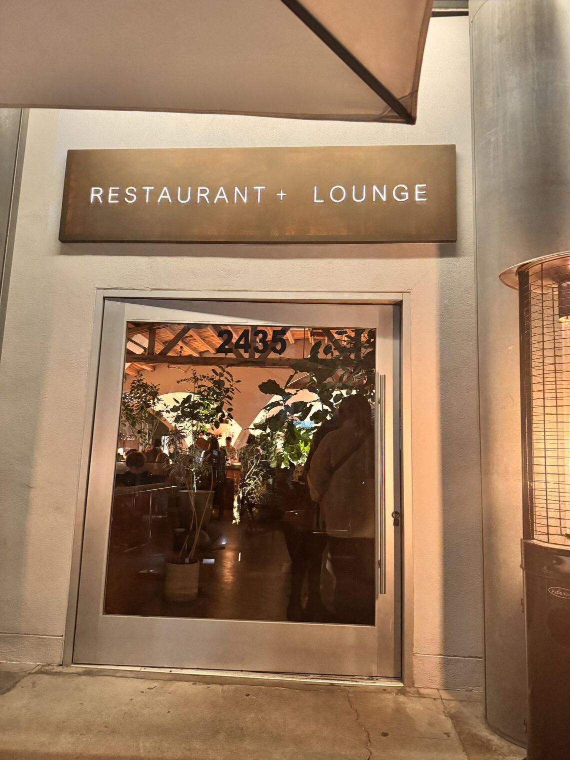 The entrance to a restaurant and lounge inside Frank Gehry's Edgemar complex in Santa Monica, with the address number 2435 marking the doorway.
