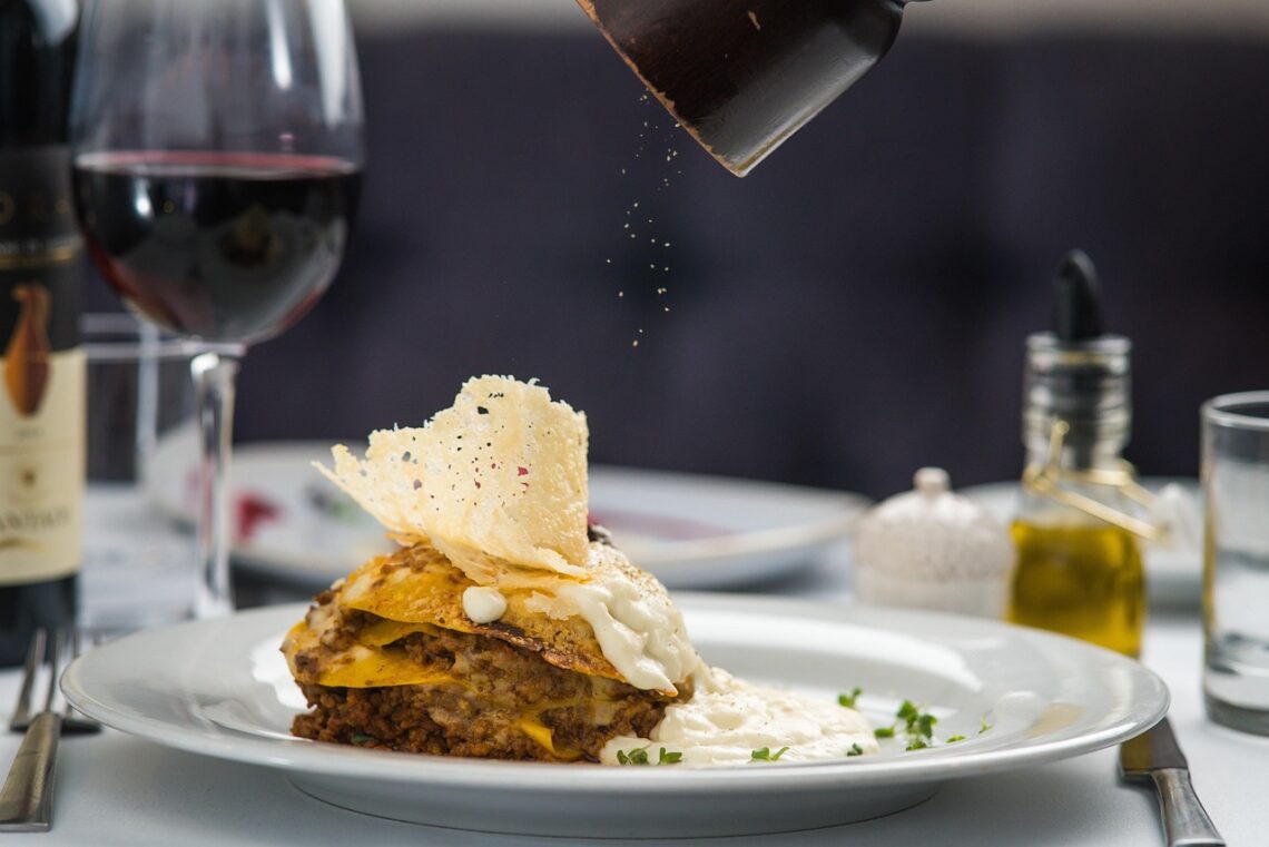 An artfully plated dish with a crisp tuile garnish, served table-side with wine glasses at an upscale Los Angeles restaurant