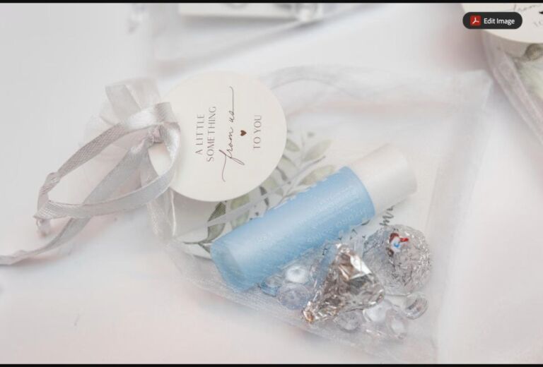 An elegant sheer organza favor bag tied with ribbon, filled with a small gift and wrapped chocolates (stock photo, used for illustration)