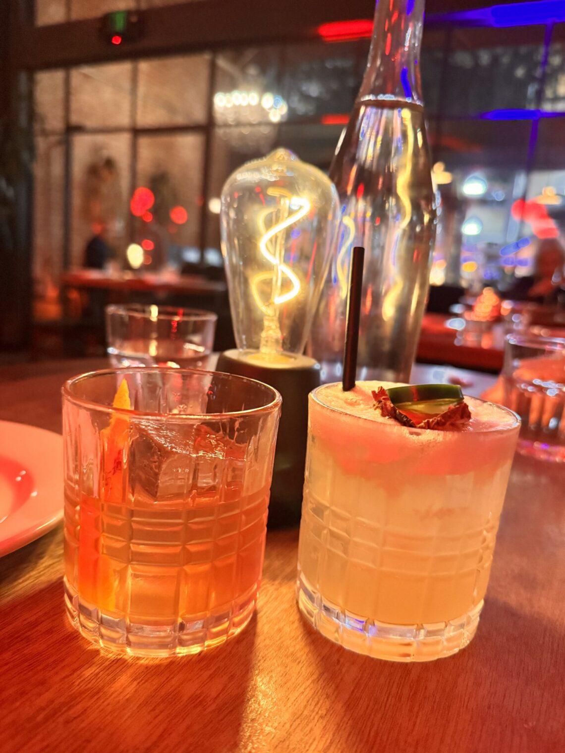 Calvados Old Fashioned and a Mezcalita D’Ananas garnished with jalapeño on the table at Massilia in Santa Monica