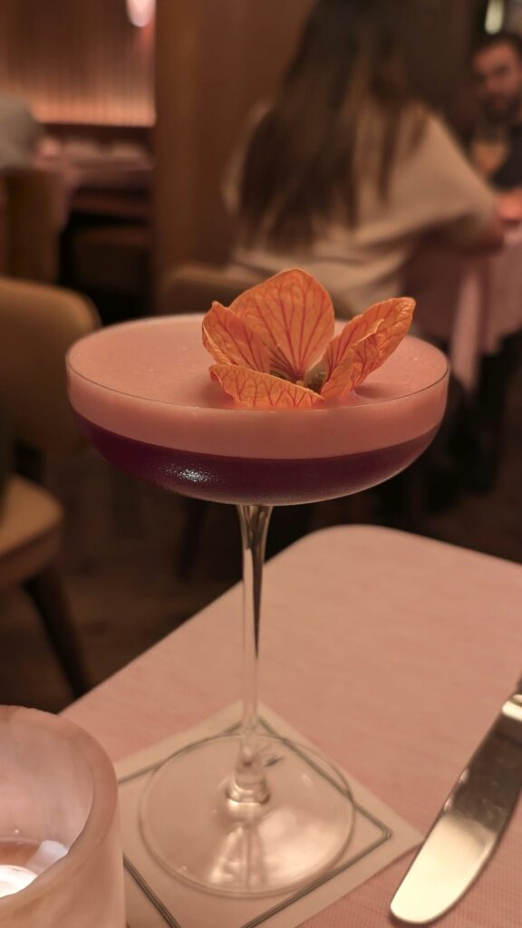 Hibiscus cocktail with an edible flower garnish at Muse Santa Monica
