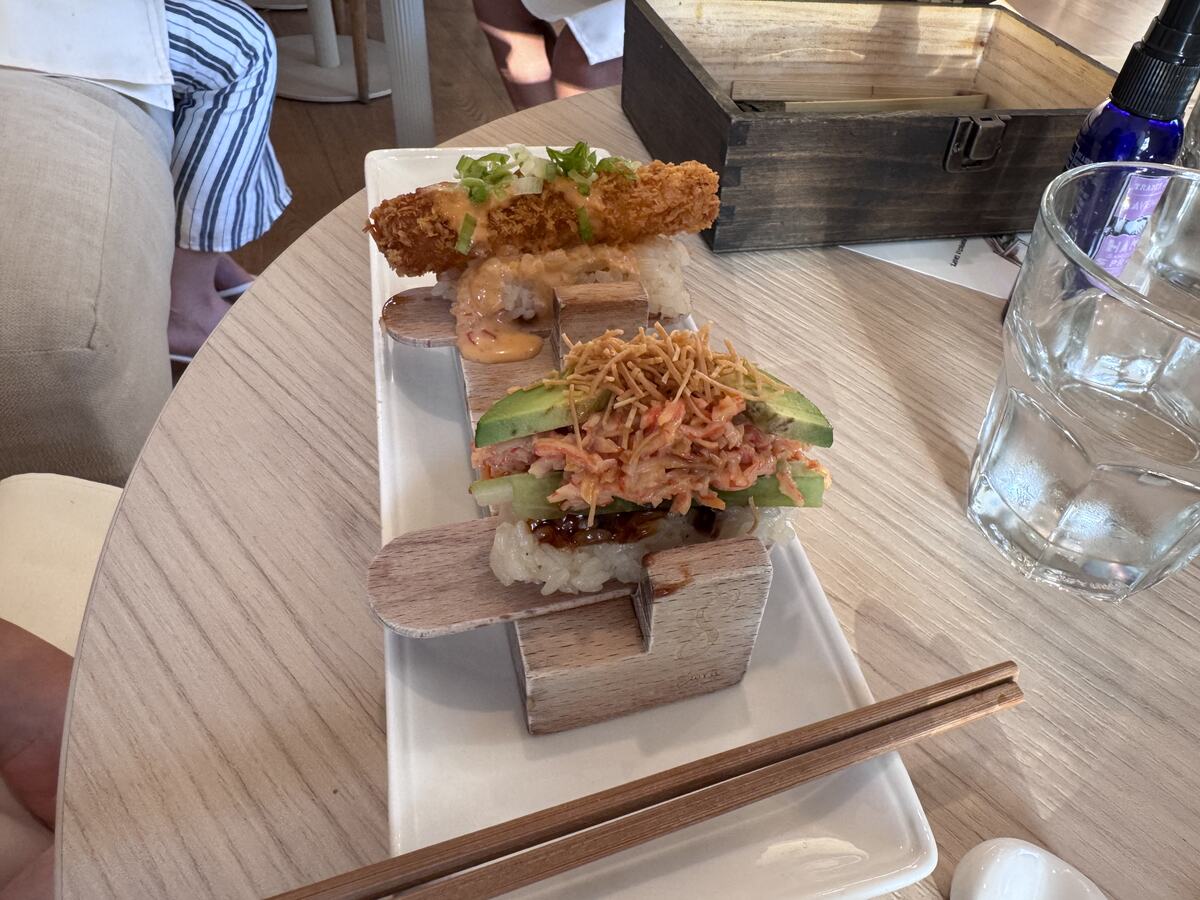 Coconut shrimp and avocado crab hand rolls topped with crispy shallots