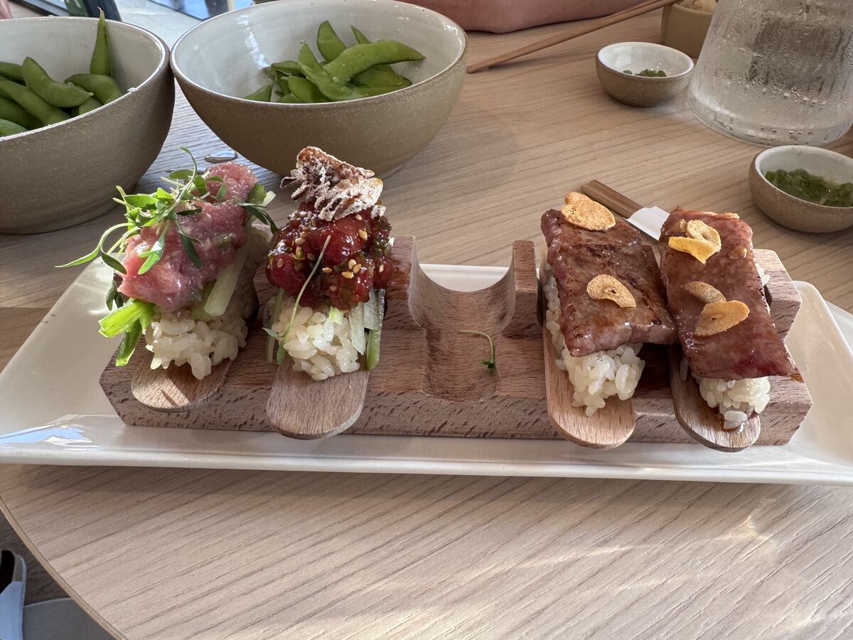 Seared wagyu and tuna hand rolls topped with crispy garlic chips