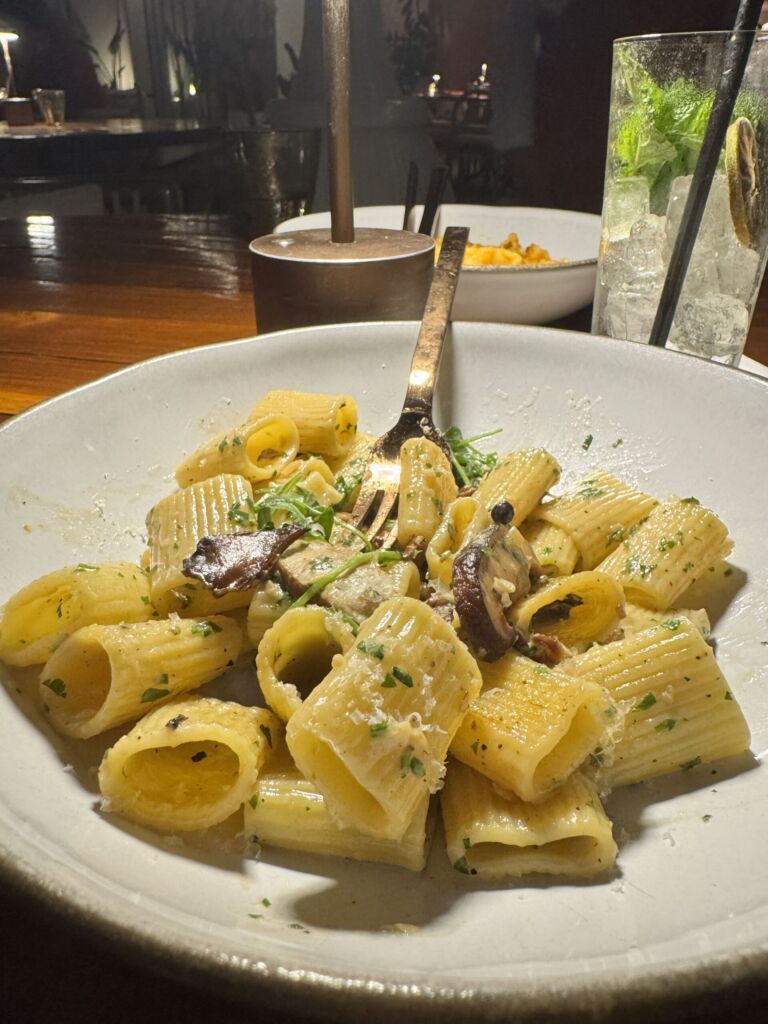 Lemon mushroom rigatoni with sliced mushrooms and fresh herbs in a white bowl at Marelle in Santa Monica