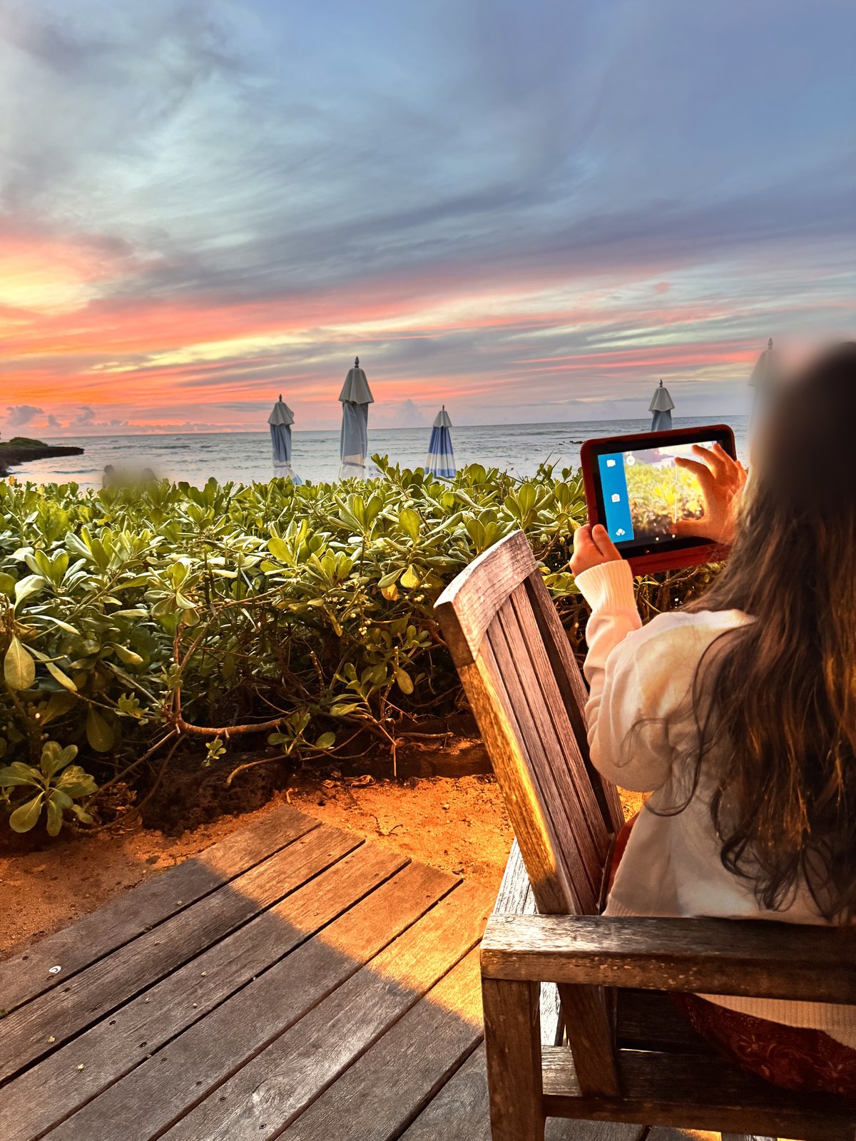 Our daughter photographing the North Shore sunset from the deck at Beach House at Turtle Bay