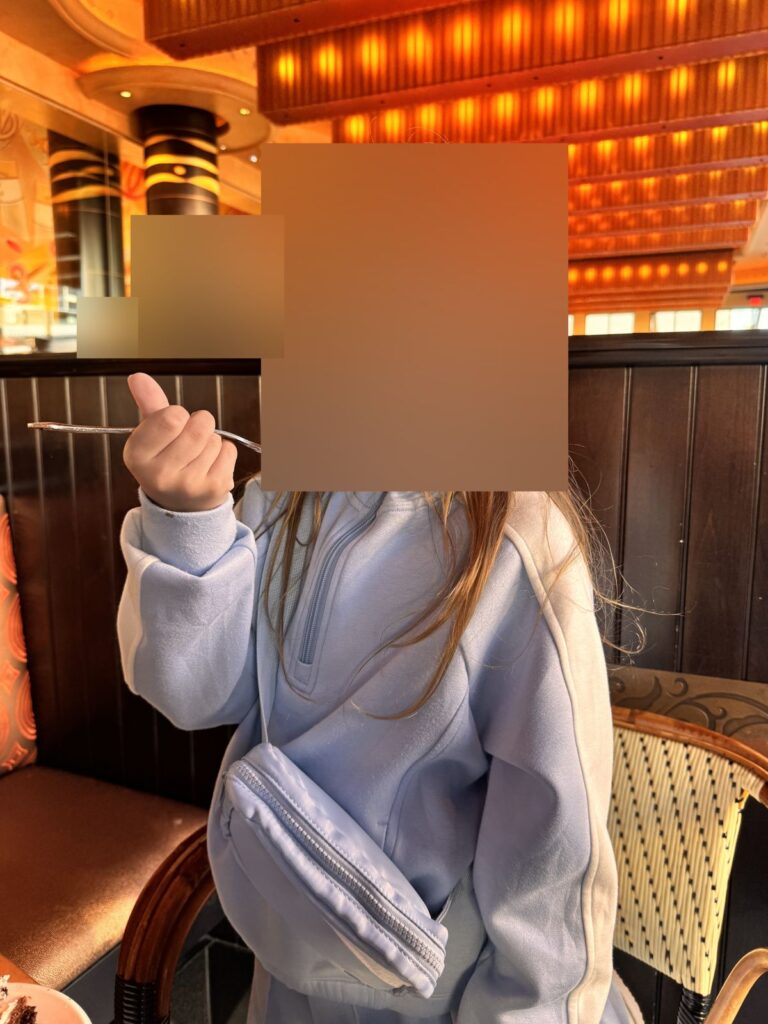 Child giving a thumbs up with a forkful of Oreo cheesecake at The Cheesecake Factory