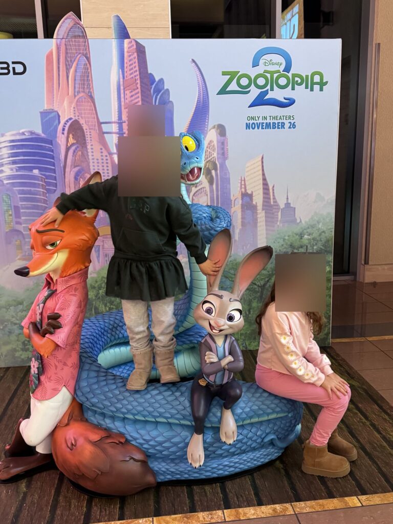 Kids posing with the movie display in the lobby at Cinemark Playa Vista, faces blurred