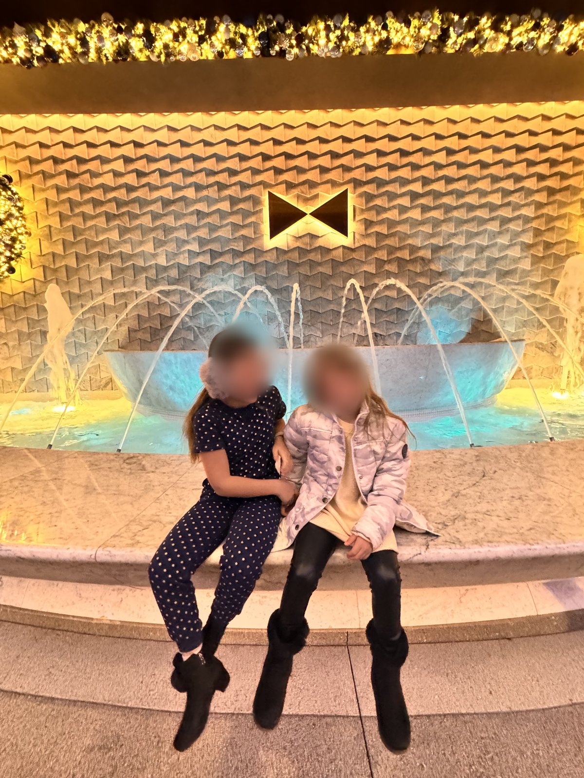 Our daughters sitting at the fountain at the front of the Fontainebleau Las Vegas, decorated for the holidays