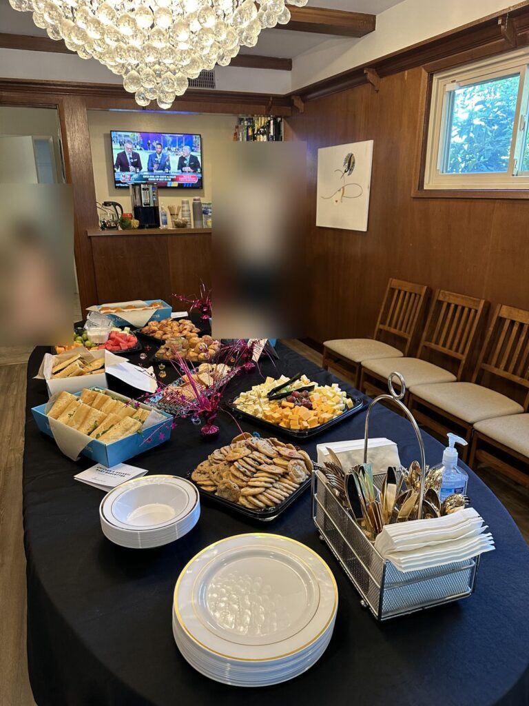 Self-serve buffet table at a home game-day party with the pregame on TV